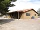 Exterior shot of a tan single story home with a covered patio and gravel landscaping at 1081 Pluto St, Pahrump, NV 89048