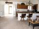 Open kitchen featuring breakfast bar, wooden cabinets and adjacent living space with glass doors to outside at 1081 Pluto St, Pahrump, NV 89048