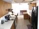 A functional kitchen with a breakfast bar, wooden cabinetry, tile floors, and light countertops at 1081 Pluto St, Pahrump, NV 89048