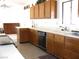 Galley style kitchen featuring wooden cabinetry, a tile floor, and light countertops at 1081 Pluto St, Pahrump, NV 89048