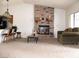 Open living space featuring a brick fireplace, kitchen bar, and a comfortable seating area at 1081 Pluto St, Pahrump, NV 89048