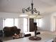 Spacious living room with modern chandelier, bright windows and comfortable seating at 1081 Pluto St, Pahrump, NV 89048