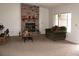 Inviting living room featuring brick fireplace, large windows, and neutral carpeting at 1081 Pluto St, Pahrump, NV 89048