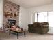 Bright living room with large window, sofa and a brick fireplace at 1081 Pluto St, Pahrump, NV 89048