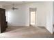 Open living space featuring neutral carpet, a ceiling fan, and a doorway leading to another room at 1081 Pluto St, Pahrump, NV 89048