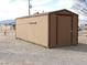 Tan shed with brown trim and gravel landscaping at 1081 Pluto St, Pahrump, NV 89048