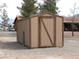 Tan shed with brown trim and gravel landscaping and view of the house at 1081 Pluto St, Pahrump, NV 89048