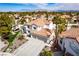 Panoramic aerial view of a home with tile roof, desert landscaping and mountain views at 1600 Windsford Cir, Las Vegas, NV 89117