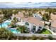 Sweeping aerial view of a luxurious neighborhood featuring backyard oasis, community pool and mountain views at 1600 Windsford Cir, Las Vegas, NV 89117