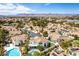 Aerial view of houses with tiled roofs, pristine pools, gardens, and mountain views at 1600 Windsford Cir, Las Vegas, NV 89117