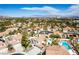 Stunning aerial view of a community with lush greenery, sparkling pools, and tile roofed homes at 1600 Windsford Cir, Las Vegas, NV 89117