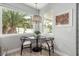 Bright breakfast nook with a round table, two chairs, and a window overlooking lush greenery at 1600 Windsford Cir, Las Vegas, NV 89117