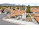 Aerial view showcases a home with a terracotta roof, a backyard firepit and stock tank pool, and lush landscaping at 2021 Summit Pointe Dr, Las Vegas, NV 89117