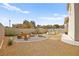 Charming backyard with gravel, relaxing Adirondack chairs circling a cozy fire pit, and a stock tank pool for summer enjoyment at 2021 Summit Pointe Dr, Las Vegas, NV 89117
