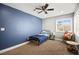 Bright bedroom features a ceiling fan, large window, and blue accent wall at 2021 Summit Pointe Dr, Las Vegas, NV 89117