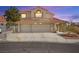 Two-story home with a tile roof and a three-car garage provides an inviting curb appeal at 2021 Summit Pointe Dr, Las Vegas, NV 89117