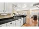 Open kitchen with white cabinetry, black countertops, and an adjacent dining area at 2021 Summit Pointe Dr, Las Vegas, NV 89117