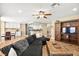 Bright living room features a dark sofa, barn wood entertainment center and adjoining dining area at 2021 Summit Pointe Dr, Las Vegas, NV 89117