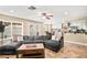 Bright living room features a large sectional sofa and access to the backyard through French doors at 2021 Summit Pointe Dr, Las Vegas, NV 89117
