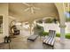 Relaxing covered patio with lounge chairs and a hanging chair overlooking green lawn at 2021 Summit Pointe Dr, Las Vegas, NV 89117