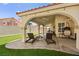 Inviting covered patio with lounge chairs and hanging chair overlooking green space at 2021 Summit Pointe Dr, Las Vegas, NV 89117
