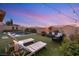 Serene backyard featuring a pool, comfortable lounge furniture, and lush artificial grass at 258 Castellari Dr, Las Vegas, NV 89138