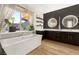 Modern bathroom featuring a soaking tub, dark cabinetry, unique light fixtures, and floating shelves at 258 Castellari Dr, Las Vegas, NV 89138