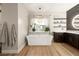 Bright bathroom featuring a soaking tub with window views, dark cabinets, and modern decor at 258 Castellari Dr, Las Vegas, NV 89138