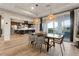 Dining area with modern light fixtures, dark wood table, and sliding glass doors at 258 Castellari Dr, Las Vegas, NV 89138