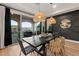 Dining area with a modern black accent wall, woven light fixtures, and sliding glass doors to the patio at 258 Castellari Dr, Las Vegas, NV 89138