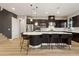 Modern kitchen featuring dark wood cabinets, stainless steel appliances, and a large island with bar seating at 258 Castellari Dr, Las Vegas, NV 89138