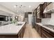 Kitchen with island, stainless appliances, dark cabinets and view into the living room at 258 Castellari Dr, Las Vegas, NV 89138