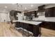 Modern kitchen featuring dark wood cabinets, stainless steel appliances, and a large island with bar seating at 258 Castellari Dr, Las Vegas, NV 89138