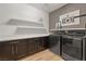 Well-organized laundry room with modern washer, dryer, shelving, and decorated wallpaper at 258 Castellari Dr, Las Vegas, NV 89138