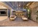 Charming outdoor patio with a fireplace, covered pergola, string lights, and modern seating at 258 Castellari Dr, Las Vegas, NV 89138