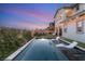 Stunning backyard pool at twilight, featuring in-pool tanning chairs and manicured landscaping at 258 Castellari Dr, Las Vegas, NV 89138
