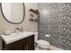 A contemporary powder room featuring a vanity, decorative wallpaper, and open shelving at 258 Castellari Dr, Las Vegas, NV 89138