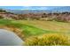 A beautiful golf course is seen with a pond and city views in the background at 2603 Savannah Springs Ave, Henderson, NV 89052