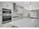Well-equipped kitchen with quartz countertops, stainless steel appliances, and designer lighting fixtures at 2603 Savannah Springs Ave, Henderson, NV 89052