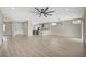 Spacious living room with modern ceiling fan, light wood floors, and open kitchen with stone countertops at 2603 Savannah Springs Ave, Henderson, NV 89052