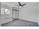 Bright bedroom featuring plush carpet, mirrored closet doors and a ceiling fan at 2716 Ferrin Rd, Las Vegas, NV 89117