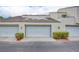 Exterior garage featuring well-maintained doors, green trim, and manicured shrubs at 2716 Ferrin Rd, Las Vegas, NV 89117