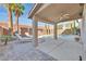 Relaxing covered patio area overlooking a pool, palm trees and brick privacy wall at 3065 Lenoir St, Las Vegas, NV 89135