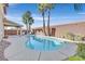A refreshing swimming pool surrounded by palm trees, a covered patio and brick wall at 3065 Lenoir St, Las Vegas, NV 89135