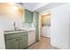 Efficient kitchen featuring light green cabinets, double sink, and adjacent laundry area for added convenience at 3141 Pinehurst Dr # C, Las Vegas, NV 89109