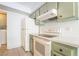 A functional kitchen featuring light green cabinets, white appliances and modern amenities at 3141 Pinehurst Dr # C, Las Vegas, NV 89109