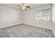 Neutral bedroom with large window, modern ceiling fan, plush gray carpet, and ample natural light at 33 Gentilly Lace Ave, Henderson, NV 89002