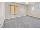 Clean bedroom with neutral walls, plush gray carpet, ceiling fan, and natural light from windows at 33 Gentilly Lace Ave, Henderson, NV 89002
