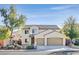 Inviting two-story home boasts a two-car garage and a well-maintained front yard with mature trees at 33 Gentilly Lace Ave, Henderson, NV 89002