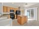 The kitchen features an island, black appliances and seamlessly connects to an additional dining area at 33 Gentilly Lace Ave, Henderson, NV 89002